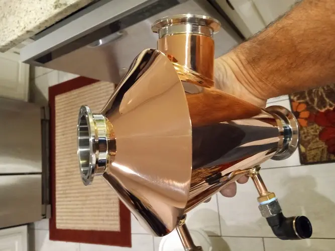 A copper Mr. Fusion still head held by hand, showing the craftsmanship up close